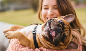 The woman is always making time to play with her dog.